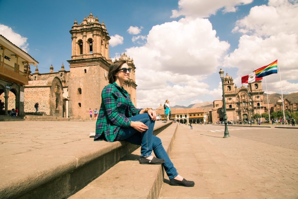 A woman sitting on steps in front of a church.