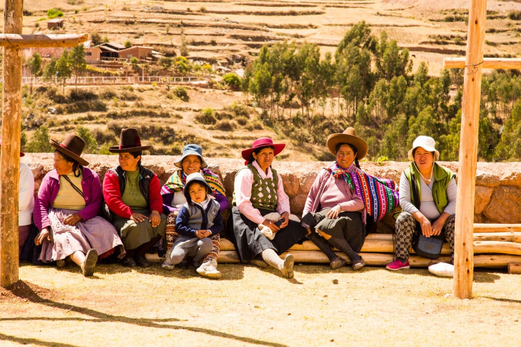 A group of people sitting on the ground in Chinchero.