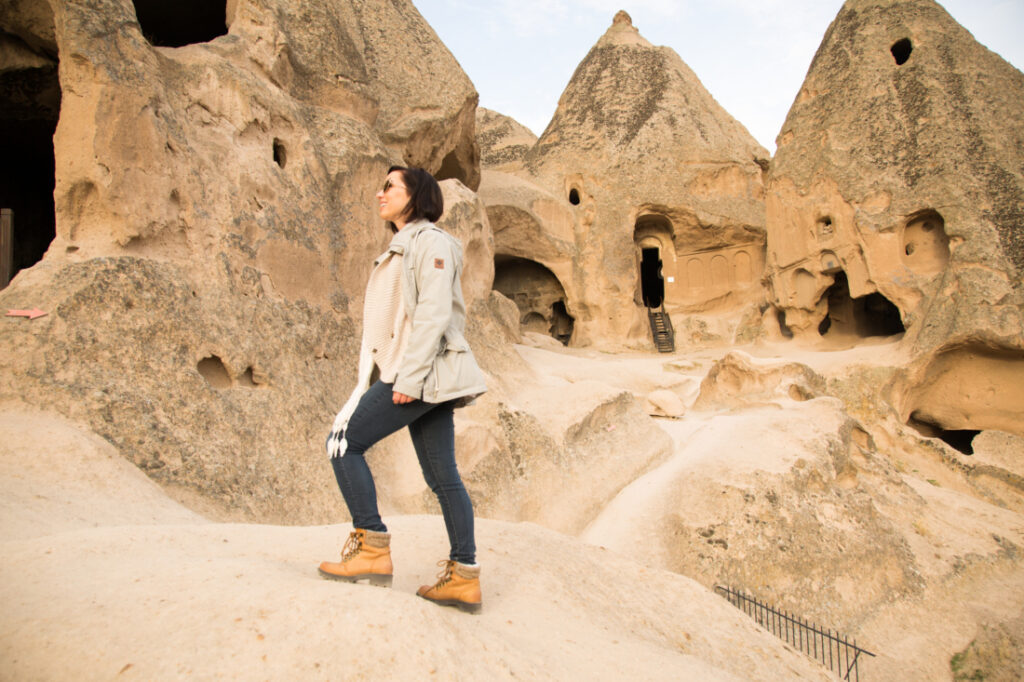 Lindsey hiking in Cappadocia Turkey, with ancient rock-cut churches at Selime Monastery in background