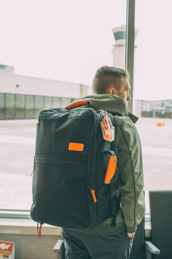 A man with a Standard’s Carry on Backpack at the airport.