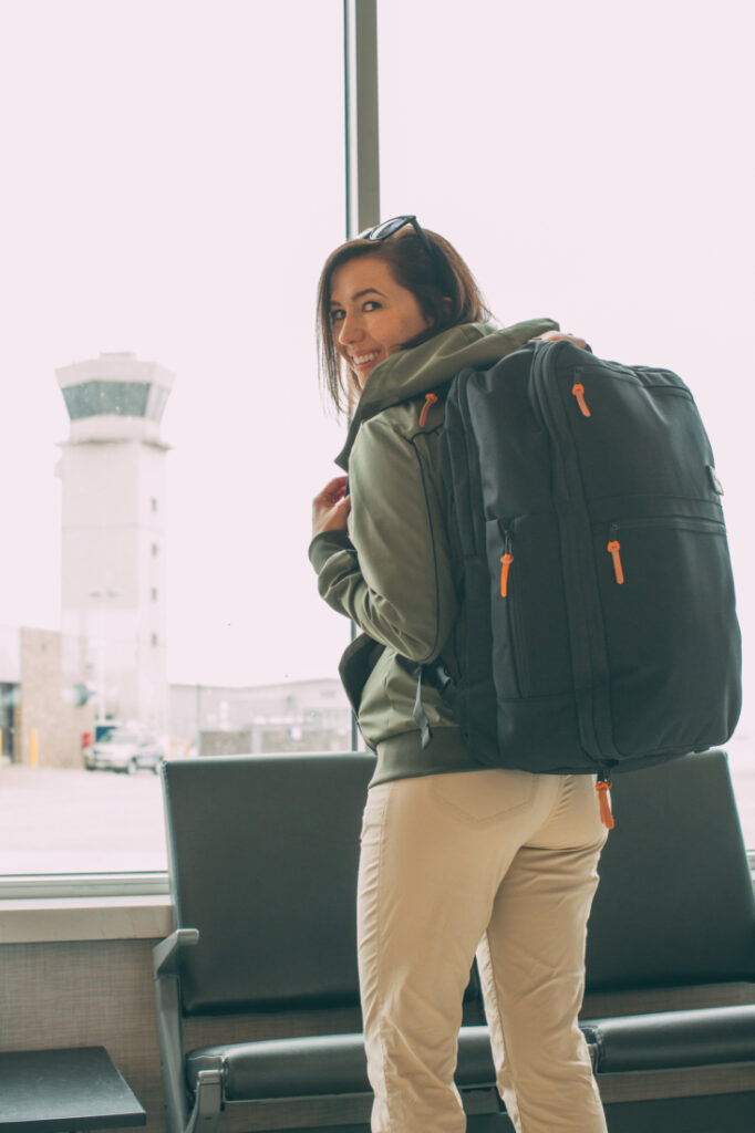 A woman with a  Standard’s Carry on Backpack in an airport.