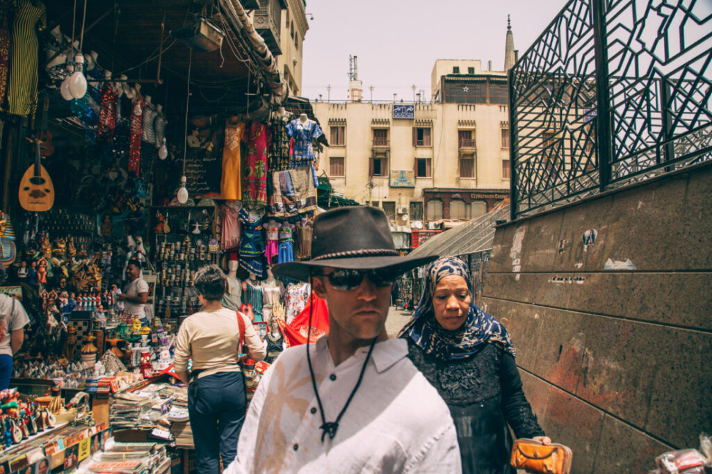 Locals and tourists browse a stall at the Khan El Khalili Bazaar, looking at the collection of jewelry and accessories.