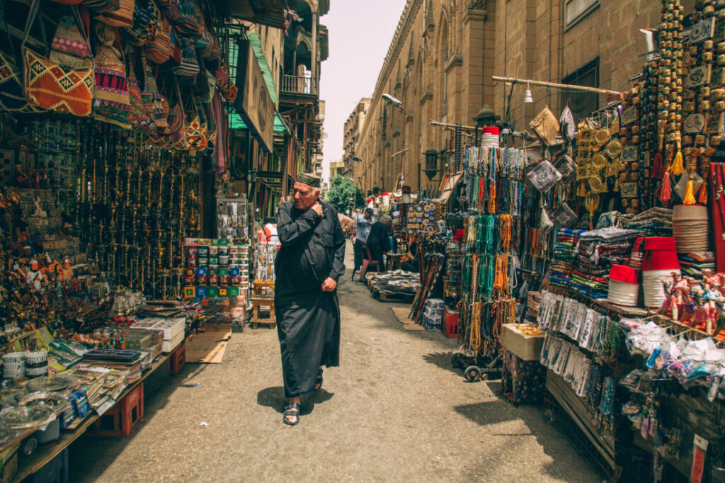 Locals walk through the packed stalls at the Khan El Khalili Bazaar, admiring the jewelry, accessories, and clothing on sale.