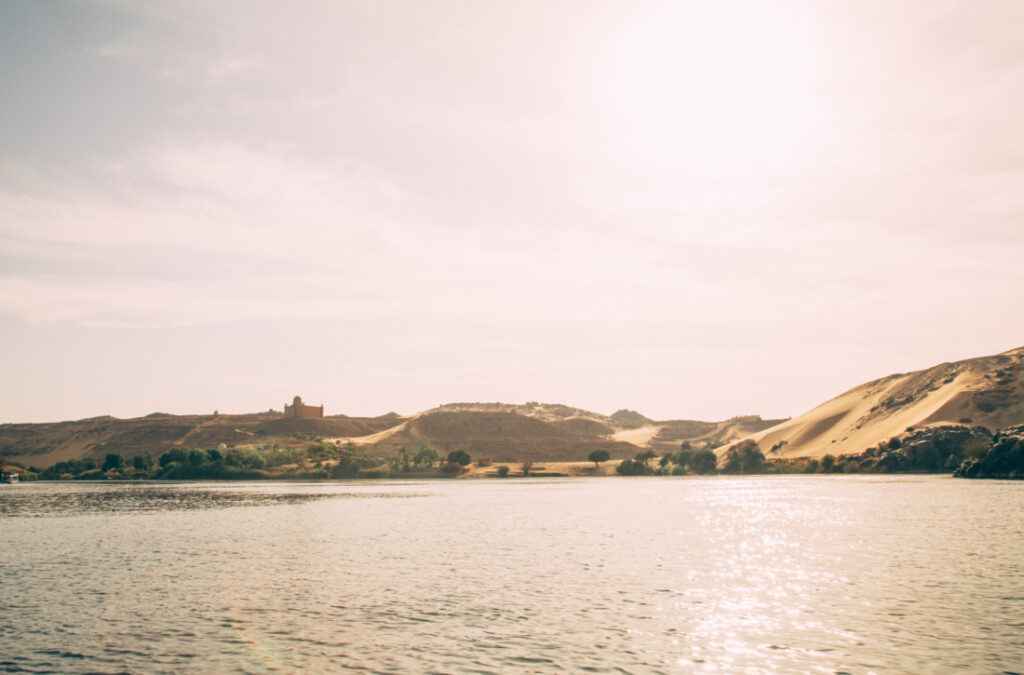 An image of the sandy desert landscape of the Nubian Village, taken from a boat along the Nile River.