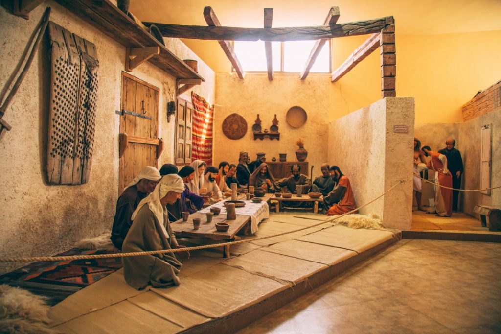 A group of people sitting around a table at La Storia Tourism Complex on the way to Mount Nebo.