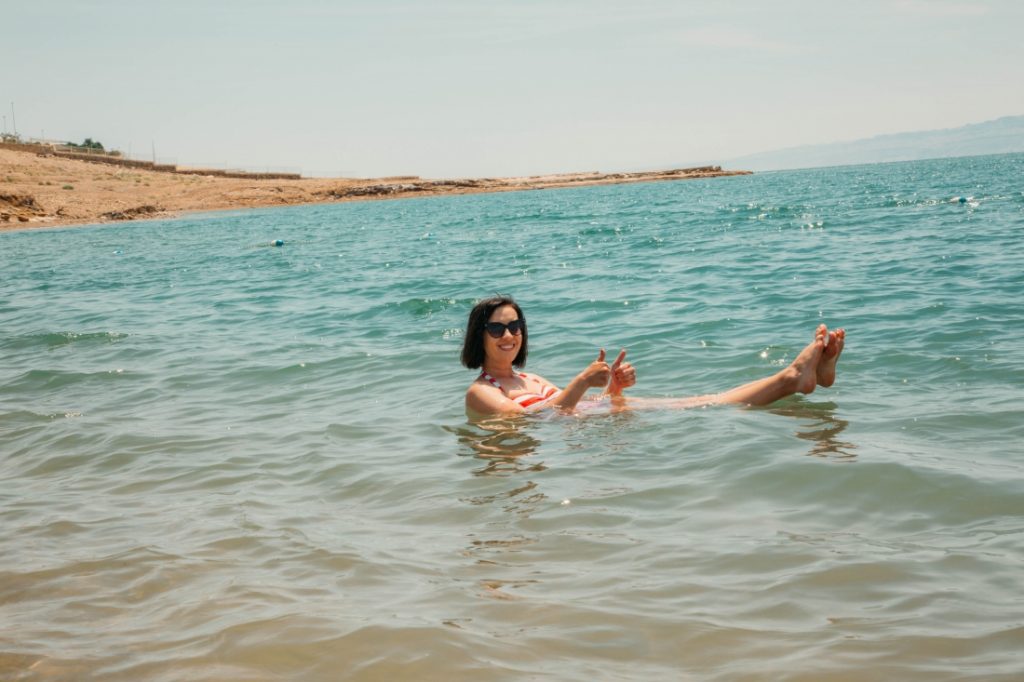 A woman in a swimsuit floating in the dead sea.