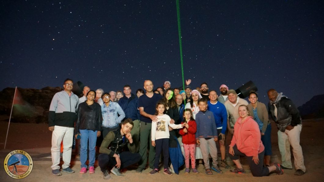 Group of different people stargazing at Wadi Rum in the night