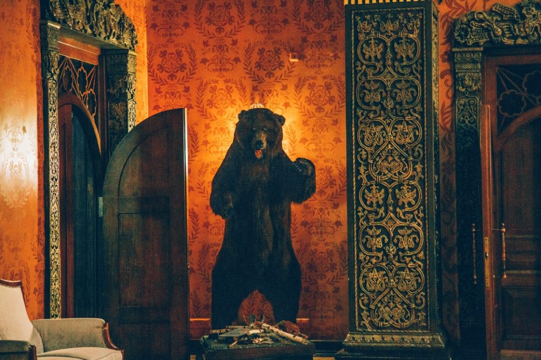 A daunting stuffed bear statue in the corner of a dining room within the Metropol Hotel. 