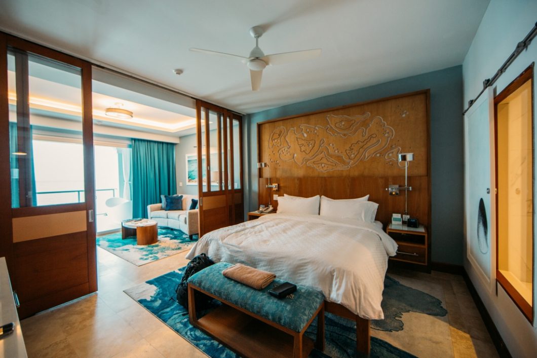 Our Sandals Montego Bay Butler Suite featuring a king sized bed with a large wooden headboard and additional sitting area 