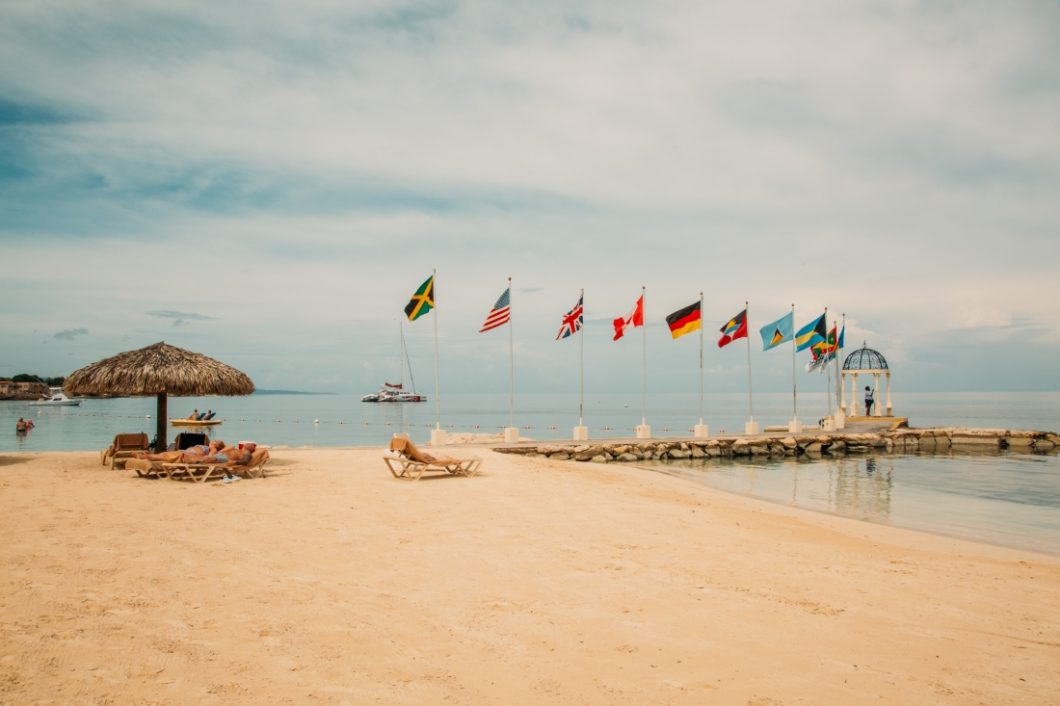 A row of international flags on a dock on the beach at Sandals Montego Bay Resort