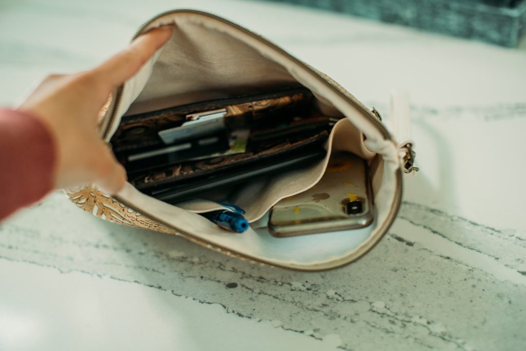 An image of a person holding open the Carry Courage INVENTOR tablet clutch case, showing all of the contents inside.