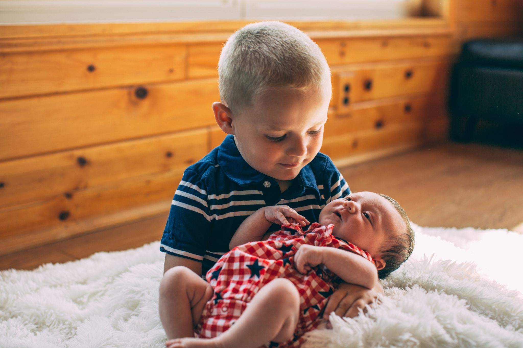 Henry holding his littler sister Claire for her newborn photos