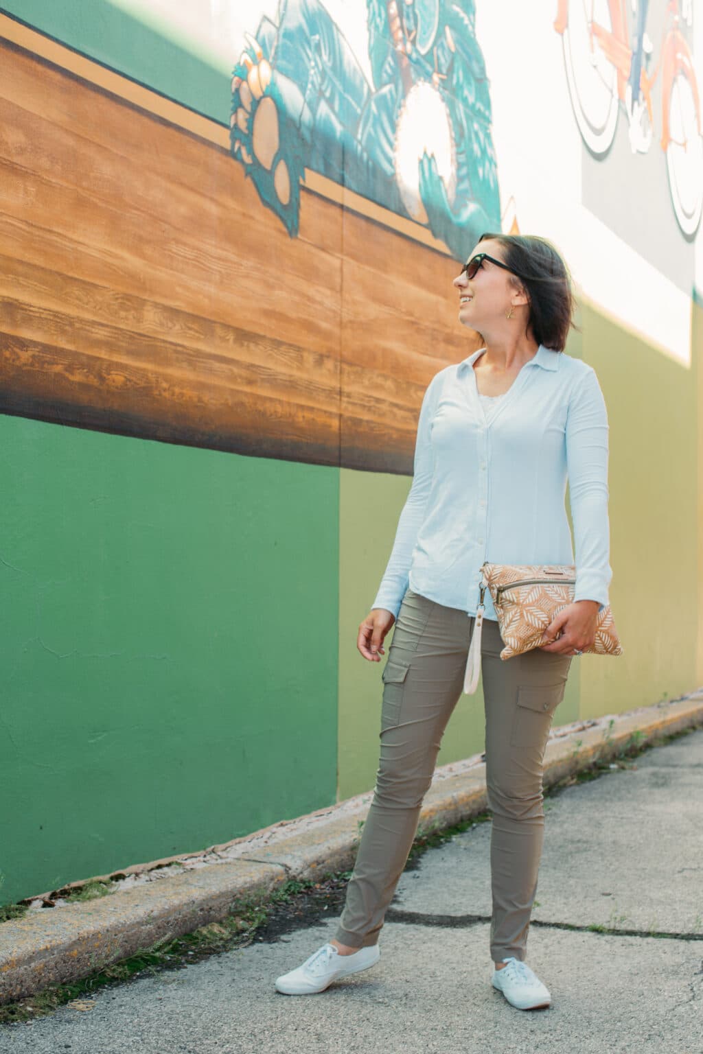 Lindsey wearing a whit e button up shirt and tan khaki pants from anatomie