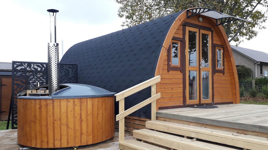 Pod Paradise Coolest Airbnb in New Zealand North Island featuring half circle wooden structure and wood fire outdoor hot tub