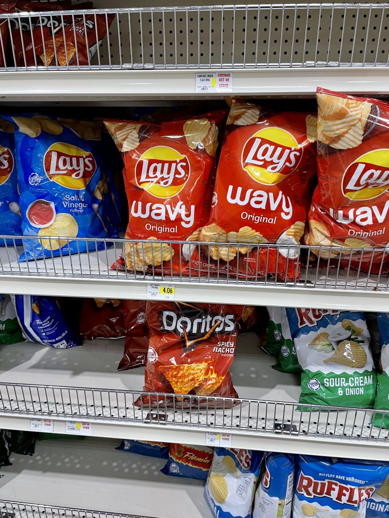 A grocery store shelf with Lays chips and Doritos in Turks and Caicos.