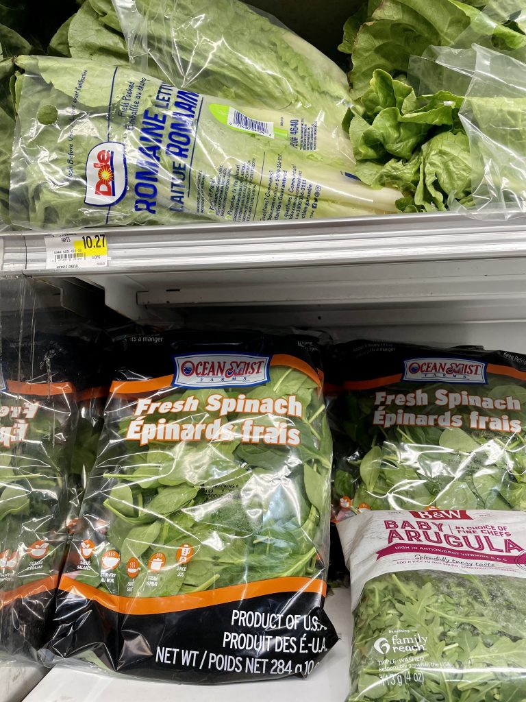 A grocery store shelf with leafy green vegetables being sold in Turks and Caicos.