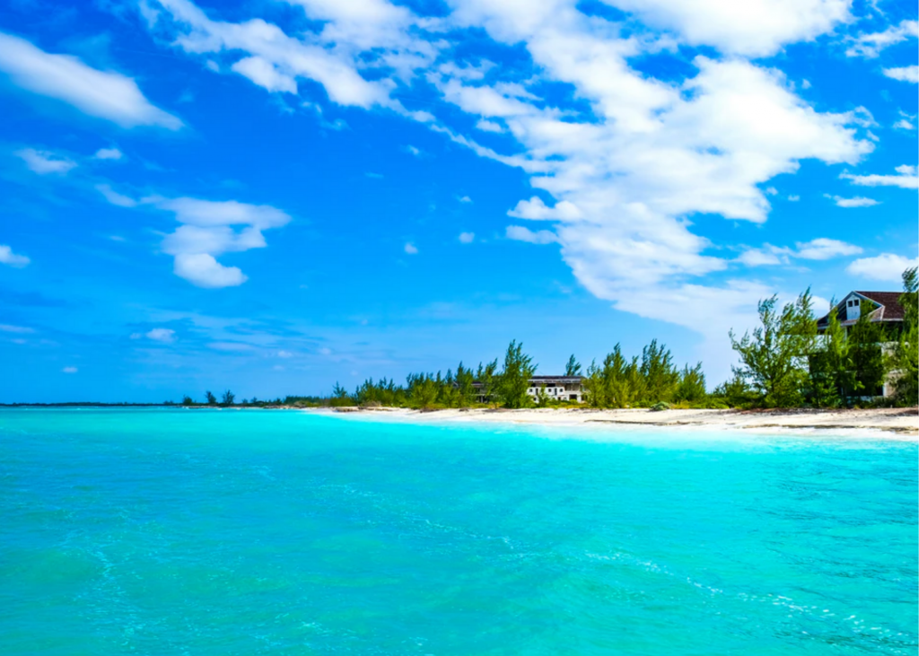 A beach with clear blue water and white sand.