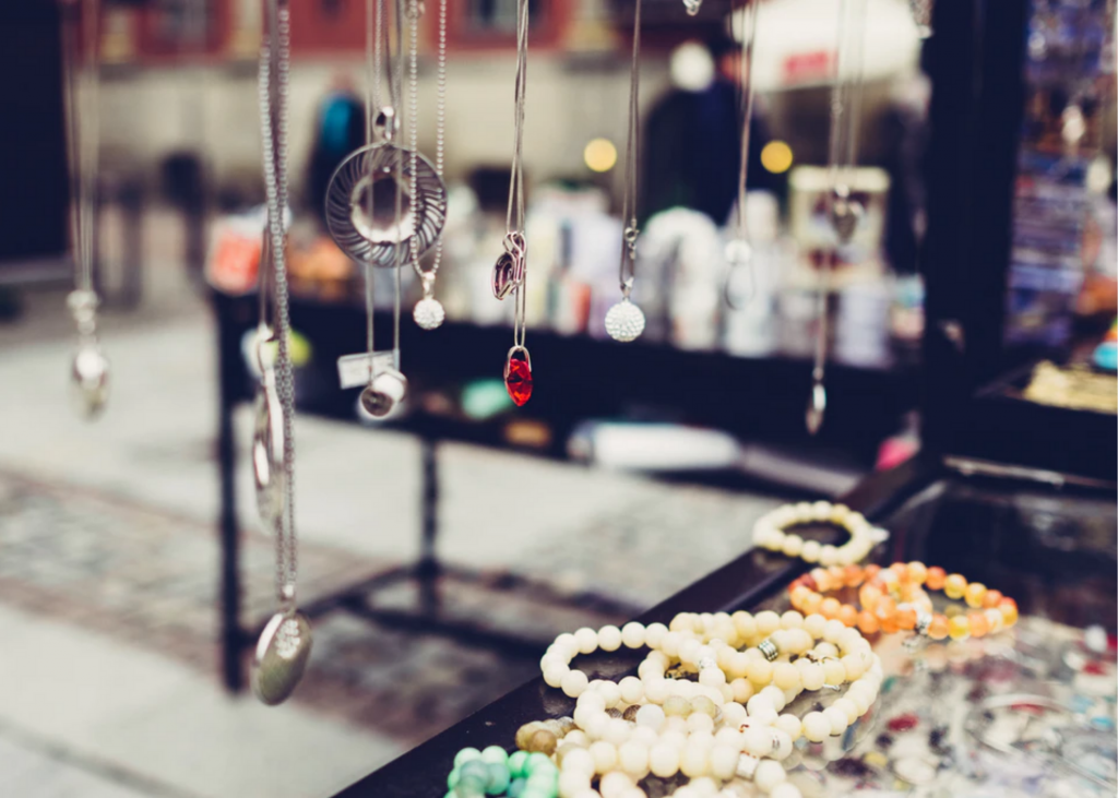 A display of necklaces and bracelets on a street.