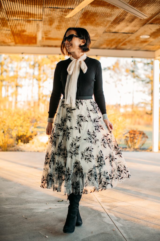 A woman wearing a mesh bow neck long sleeves ribbed knit top from Chicwish.