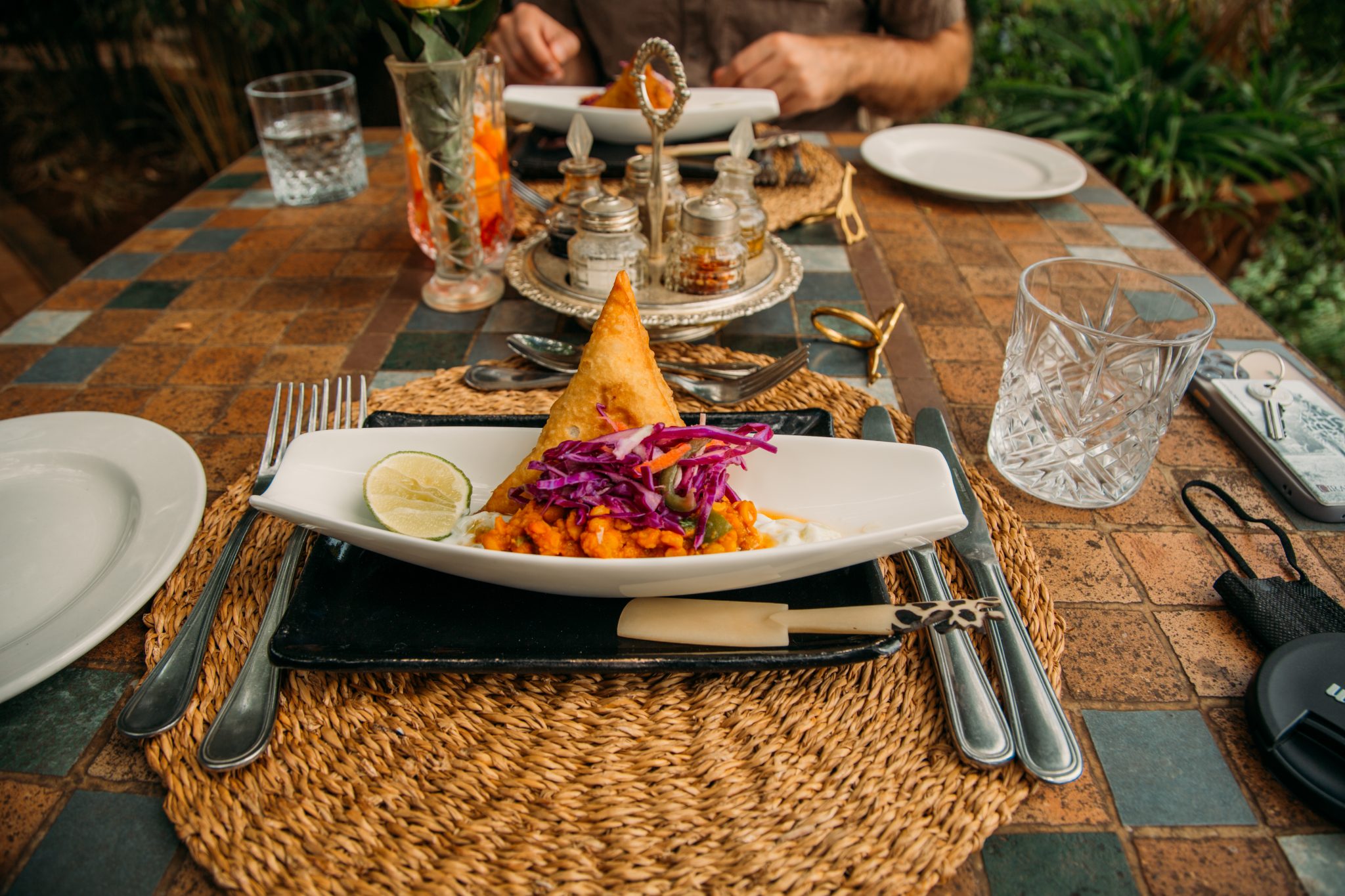 A plate of food on a table in front of a man at Giraffe Manor.