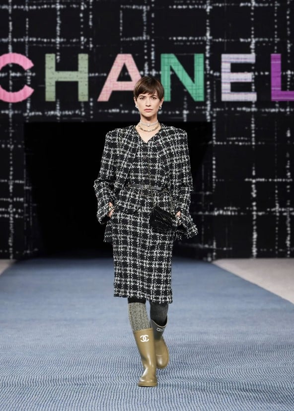 A model on the runway wearing the Chanel Tweed Suit.