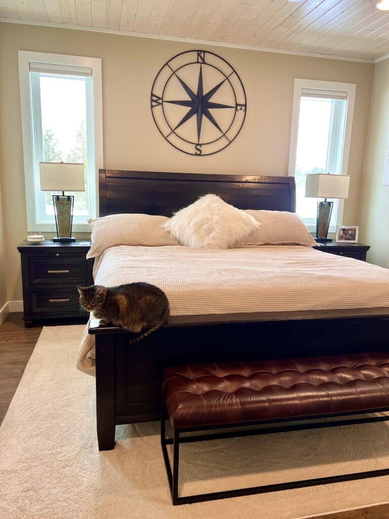 A brightly sit bedroom and king-size bed, made up with Bedsure bedding. A cat sits on the footboard of the bed.