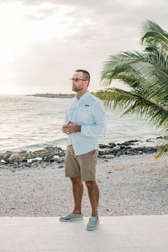 A man wearing a long-sleeve shirt on the beach. 