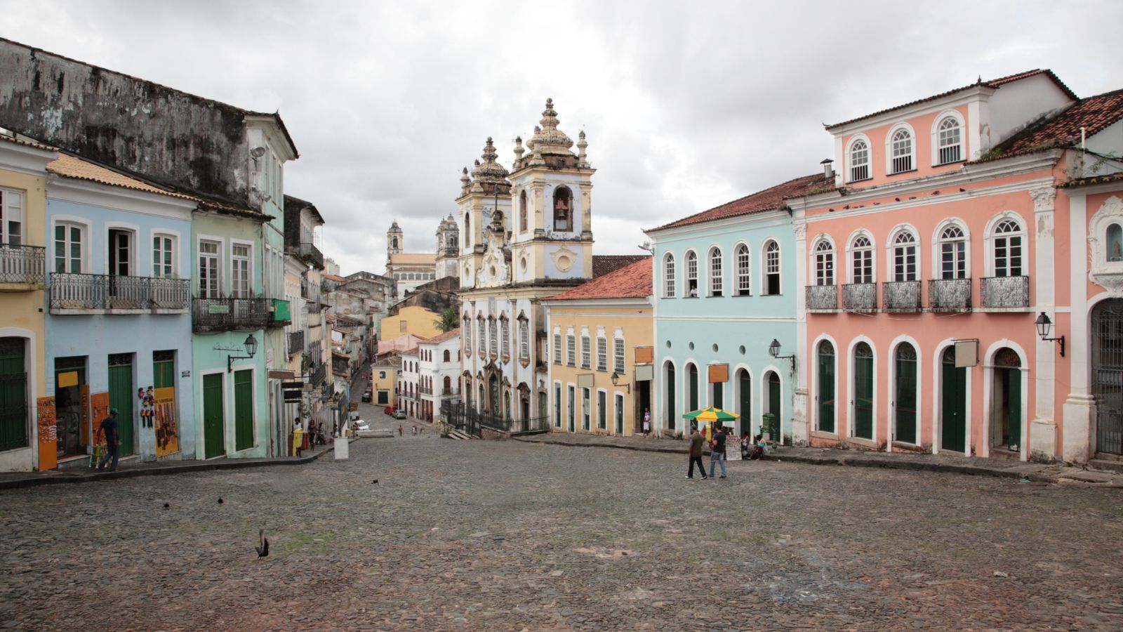 Colorful buildings line an empty street in Salvador, Brazil on a cloudy day.