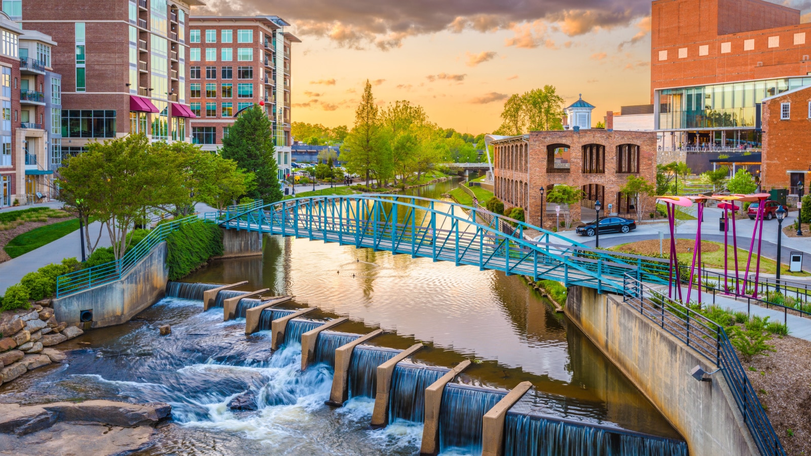 Greenville, South Carolina, USA downtown cityscape on the Reedy River at dusk.