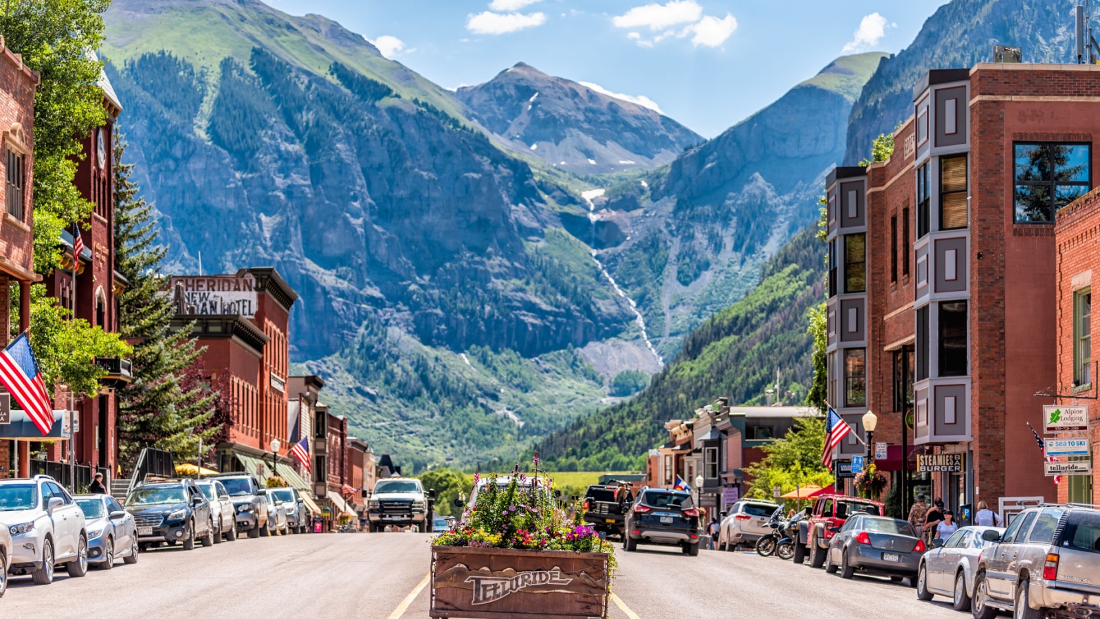 Telluride, USA - August 14, 2019: Small town village in Colorado with sign for city and flowers by historic architecture on main street mountain view