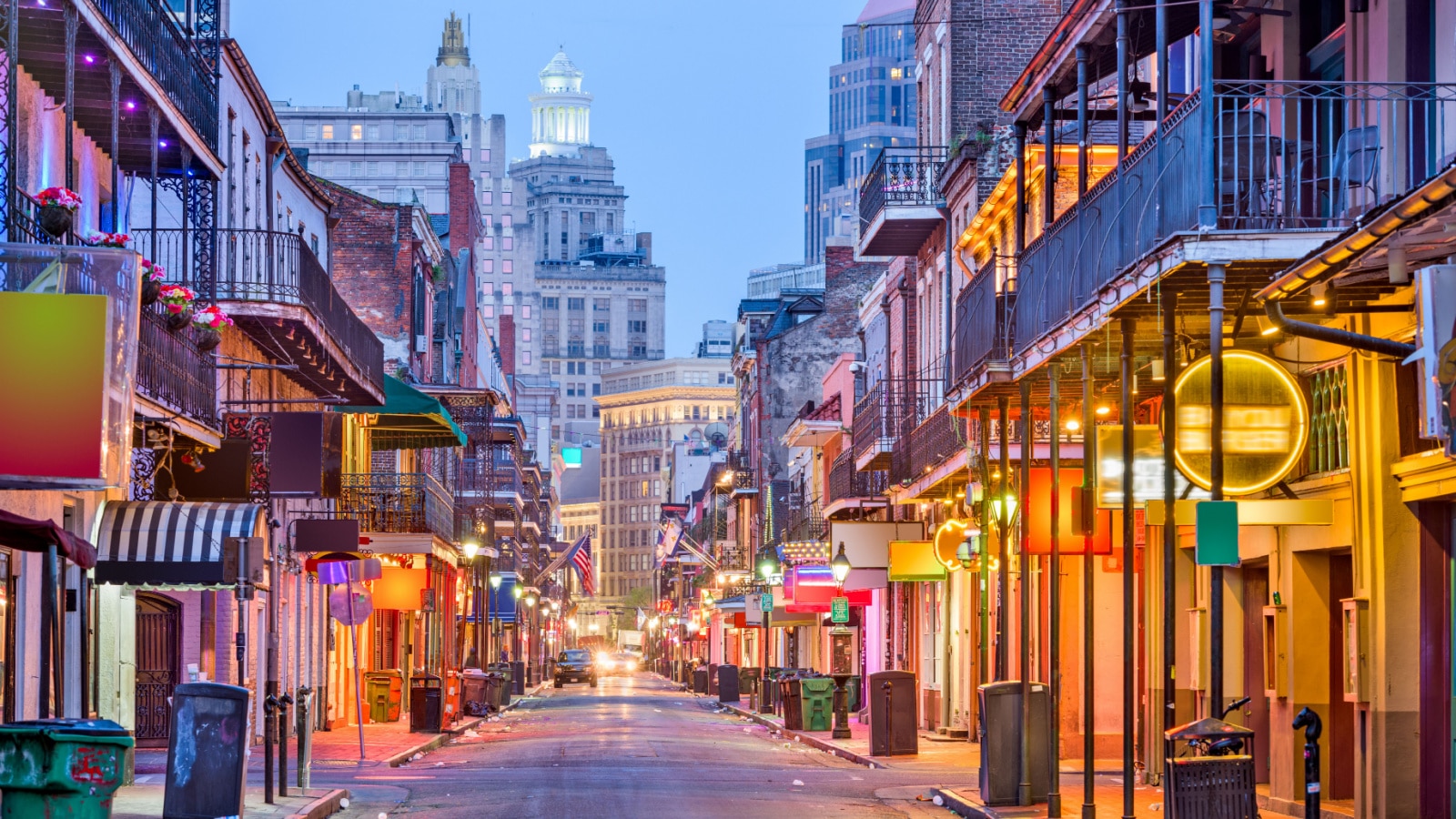 Bourbon St, New Orleans, Louisiana, USA cityscape of bars and restaurants at twilight.