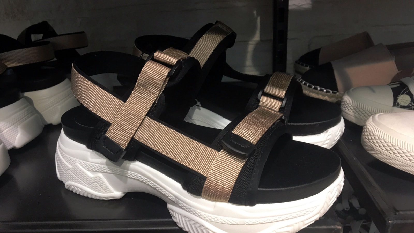 Flat sport sandals on platform with details on shelf in shoes store.Mass market shop. Close View Of Fashion Casual Female shoes. Chunky sole