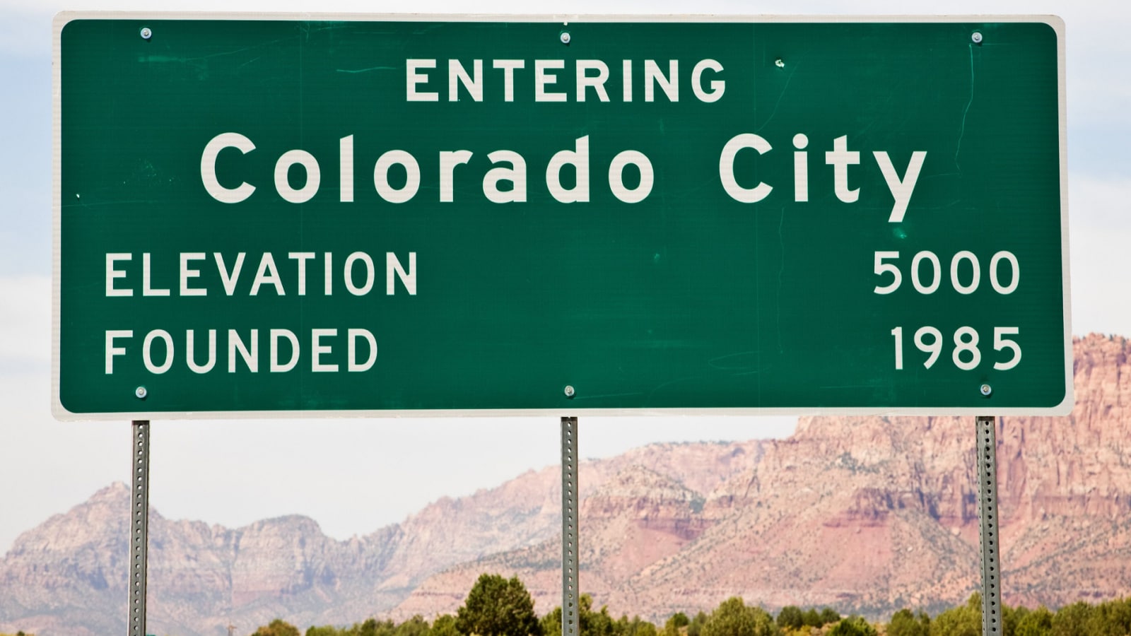 A green Colorado City city limits sign displays the elevation and year the city was founded. 