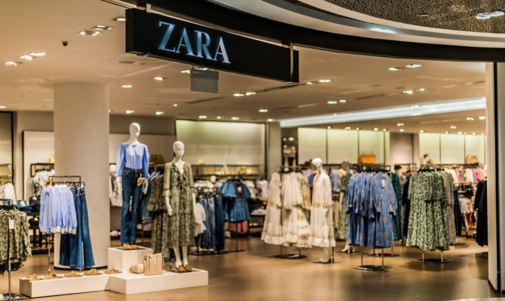 A picture of the inside of the retail clothing store Zara, filled with mannequins modeling clothing and multiple clothing racks.