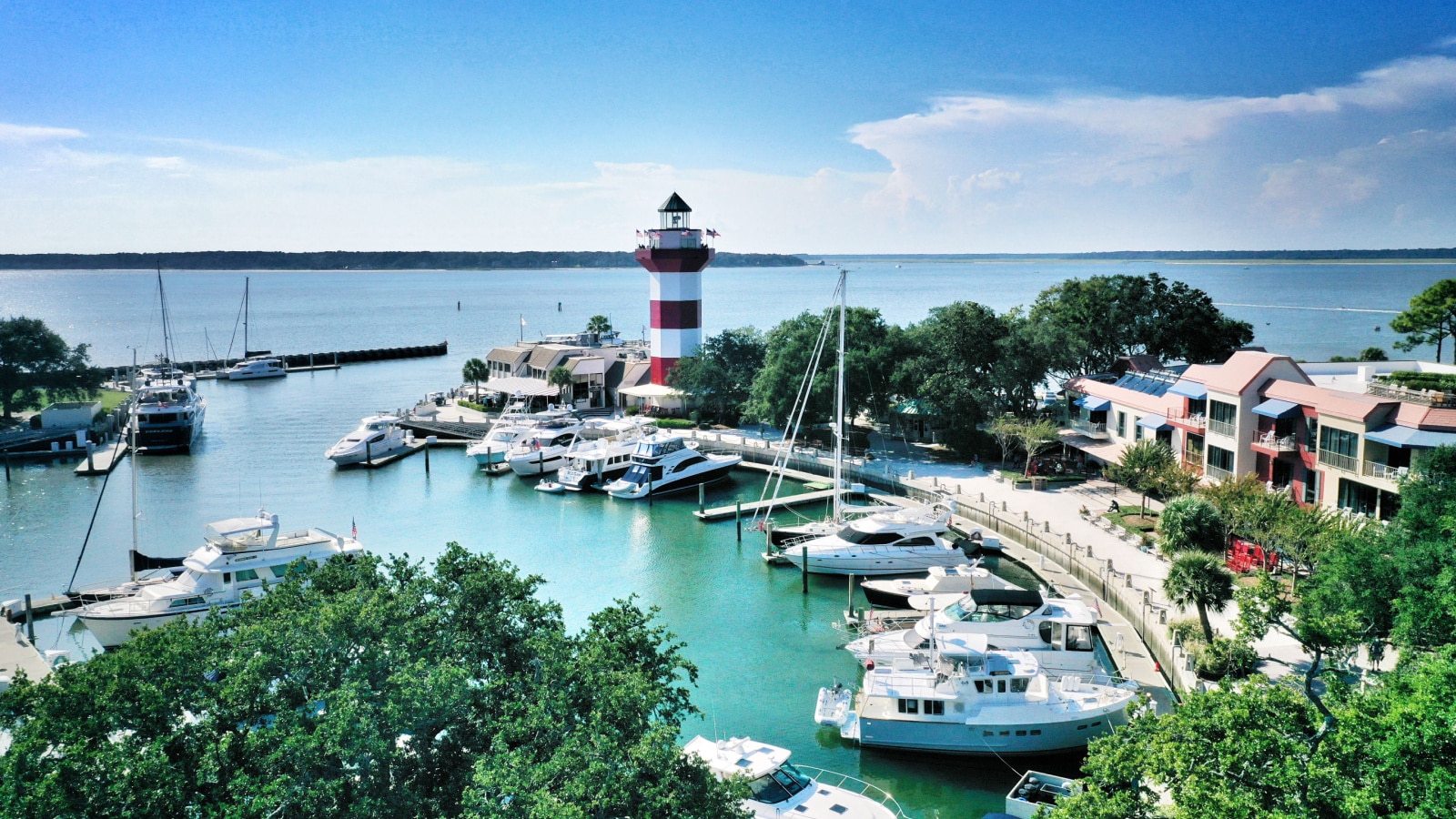 HARBOUR TOWN, HILTON HEAD ISLAND, SC, USA - SEPTEMBER 2019: Aerial view of boats moored in the marina and a lighthouse on the pier