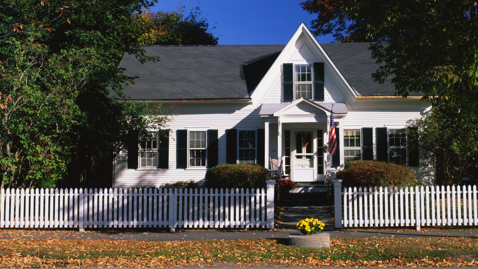 This is a typical suburban single-family home. It is a white house with a picket fence in front. This typifies the American dream for most people, New England.