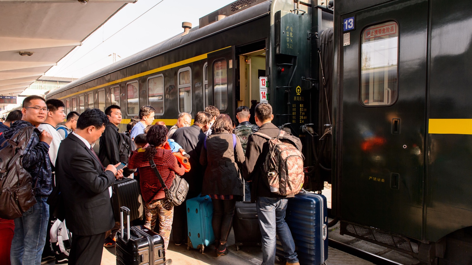 XIAN, CHINA - MAR 29, 2016: People trying to get on a train on a platform at the Central Railway station of Xian, China. THe most populated railway station in Xian, China.