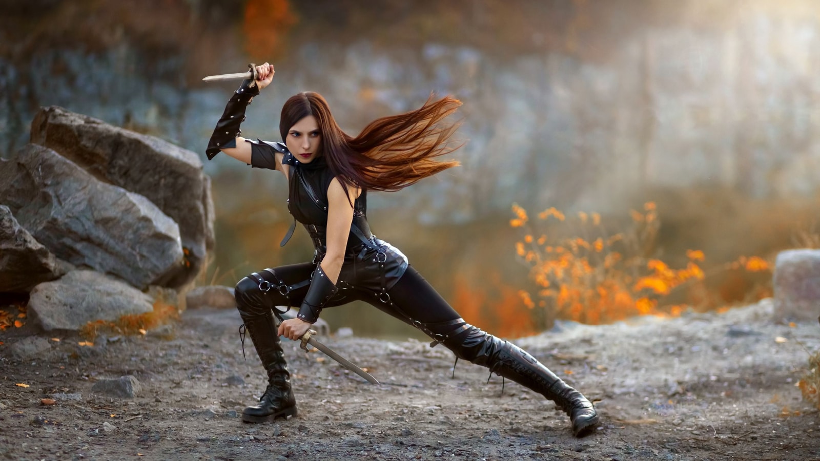 Fantasy fighting woman assassin actions in motion battle, hold daggers in hand. Red-haired girl warrior in black leather costume. ninja soldier with knives. Red long hair fluttering fly in wind.