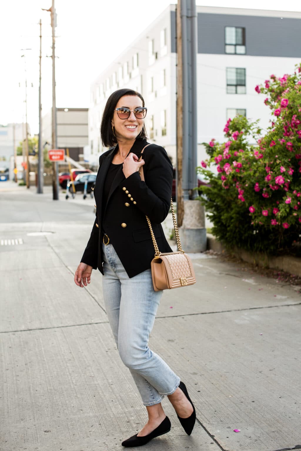 Lindsey of Have Clothes, Will Travel showing a pink Chanel boy bag paired with a black blazer and jeans