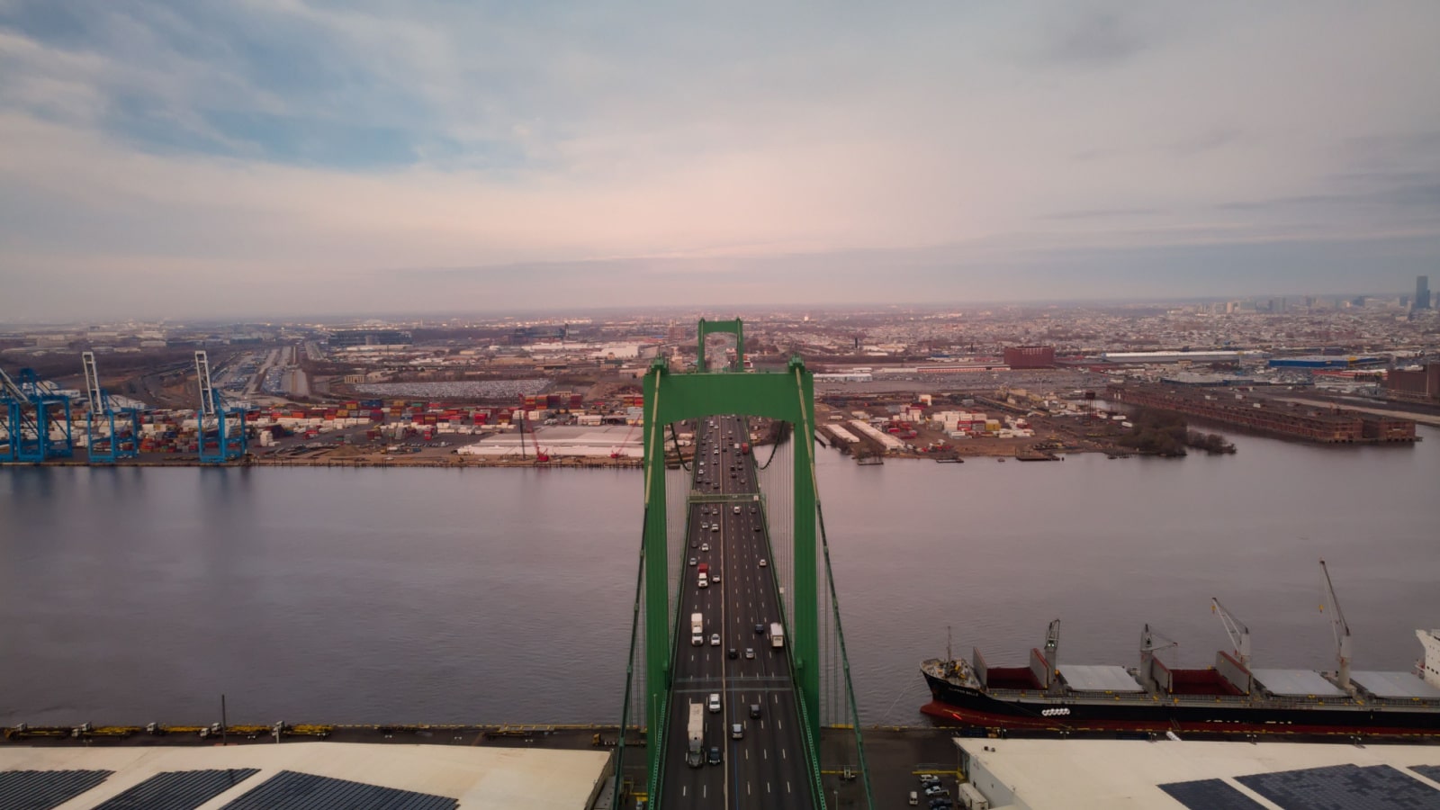 An aerial drone photo of Walt Whitman Bridge in Gloucester City, New Jersey. The bridge connects the industrial port side of the river with the more residential side of the city.