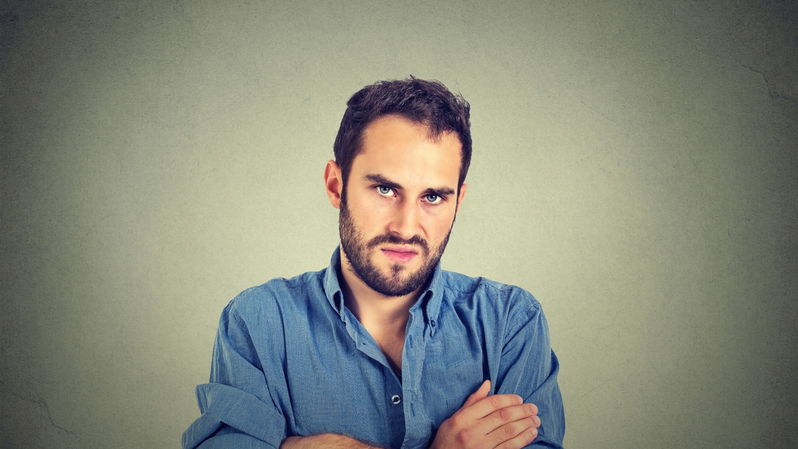 Closeup portrait of angry young man, about to have nervous breakdown, isolated on gray wall background. Negative human emotions facial expression feelings attitude