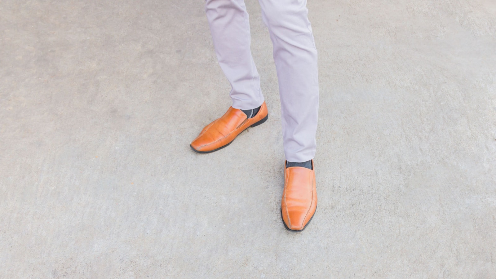 Woman wearing And brown leather shoes, standing against the wall.