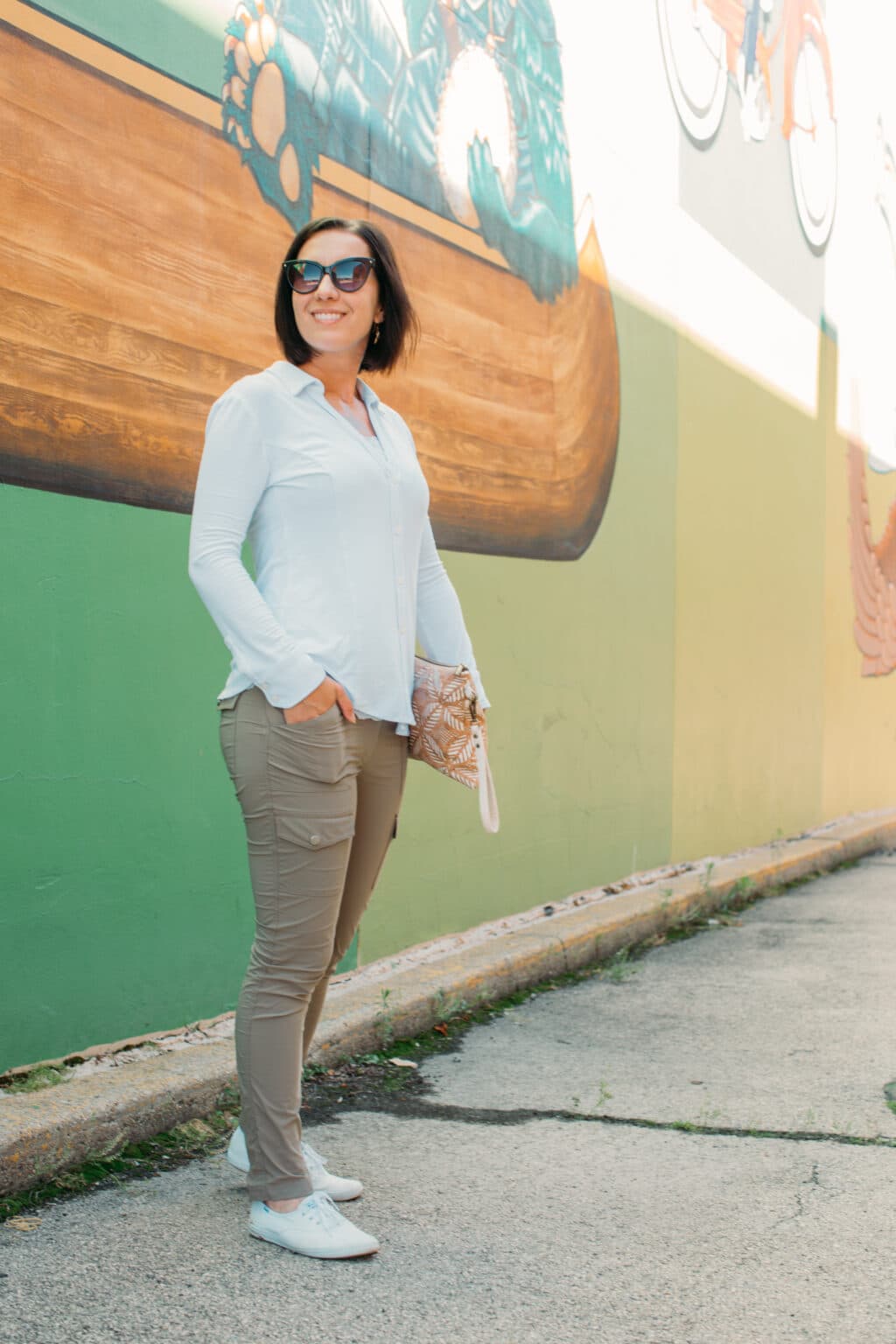 Lindsey of Have Clothes, Will Travel wearing Anatomie travel clothes for women and Keds sneakers with an urban backdrop