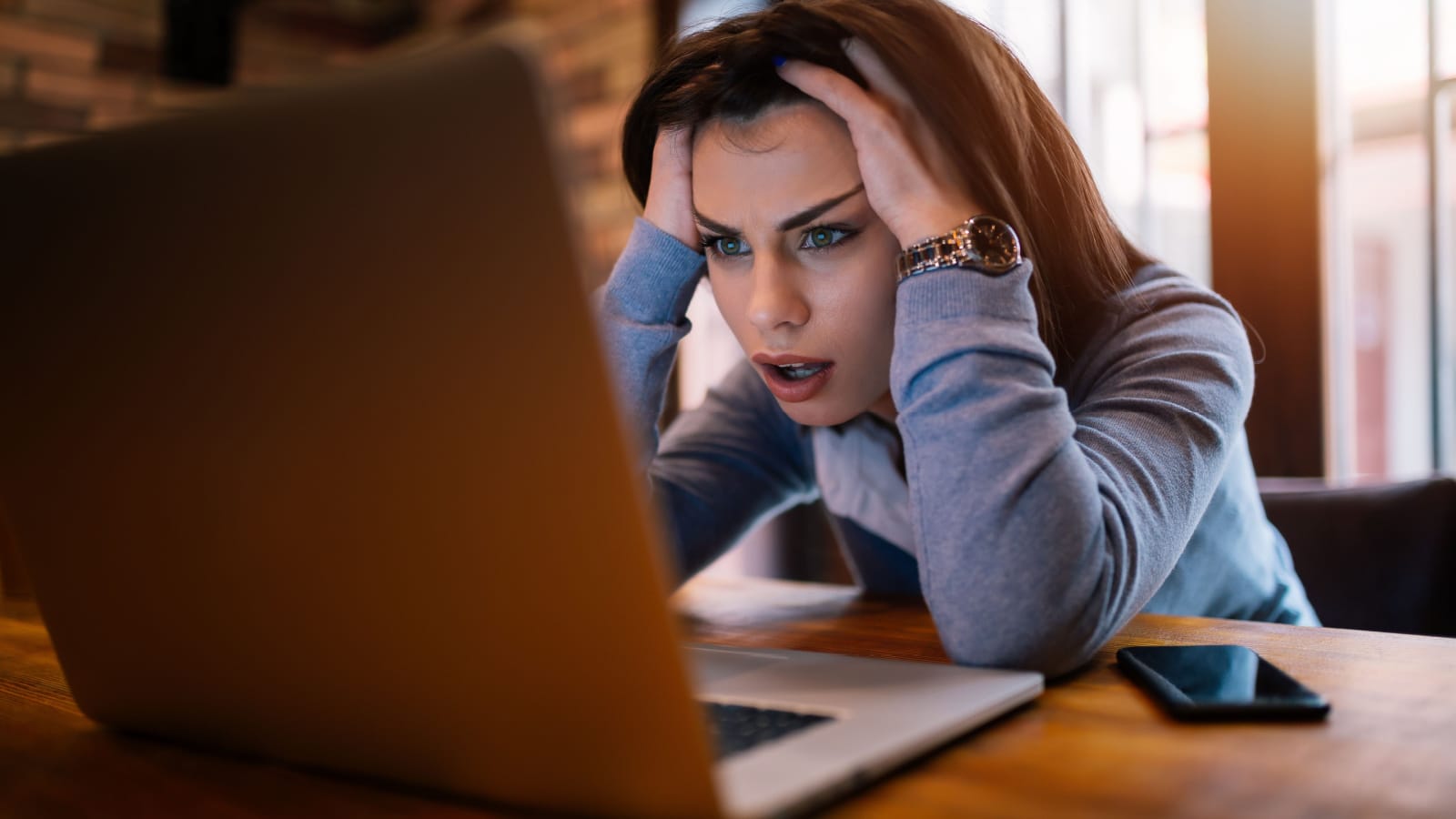 Frustrated worried young woman looks at laptop upset by bad news, teenager feels shocked afraid reading negative bullying message, stressed girl troubled with problem online or email notification.