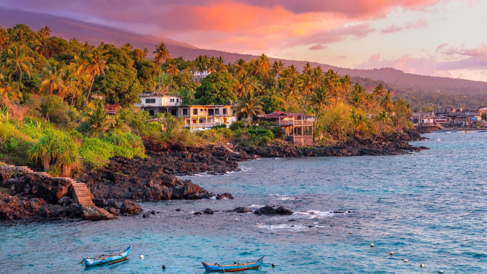 Sunset boats in holiday paradise resort on Grand Comore island, Comoros. Beautiful sunset light of sun in the sea. Villas on the beach with private beach. Moroni Comoros, Itsandra beach resort hotel