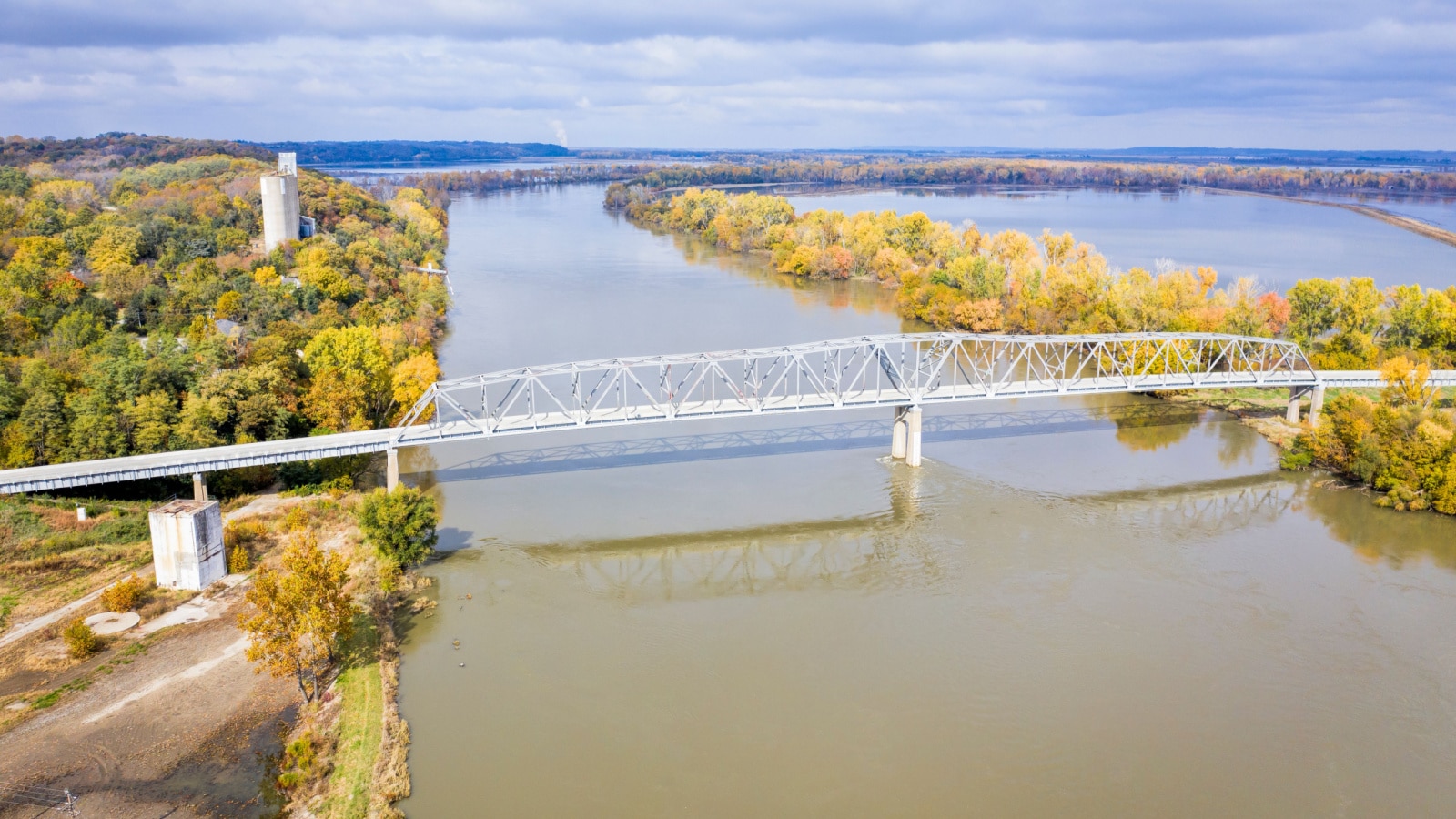 Brownville Bridge over the Missouri River on U.S. Route 136 from Nemaha County, Nebraska, to Atchison County, Missouri, at Brownville, Nebraska, aerial view in fall scenery with flooded river.