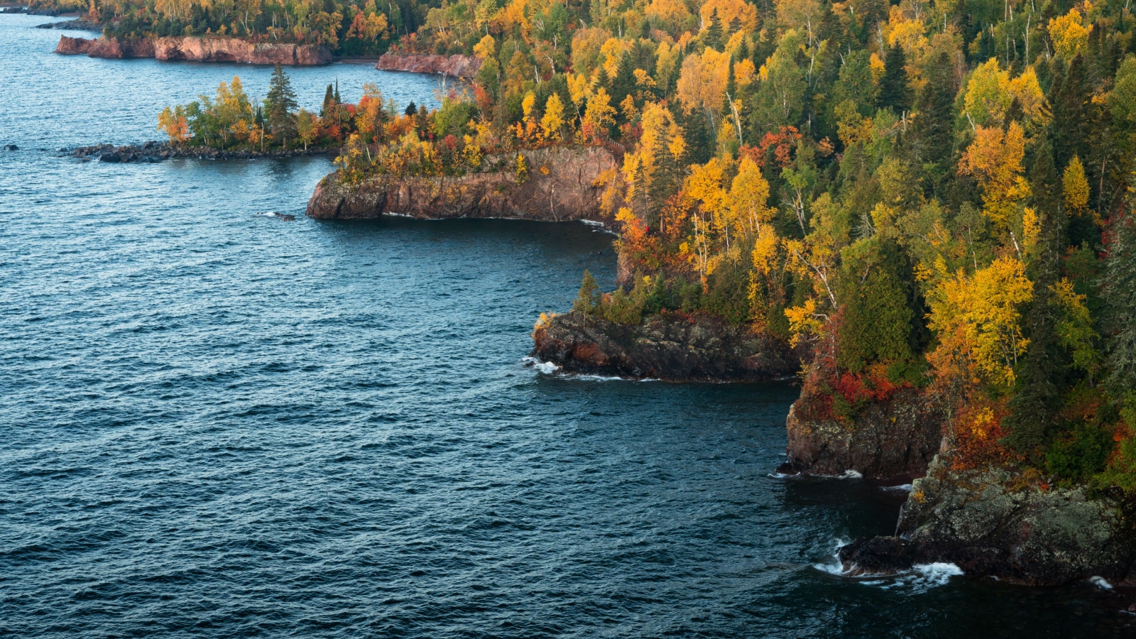 Sunrise slowly begins to light up the rocky shoreline of Tettegouche State Park along Minnesota's north shore of Lake Superior.