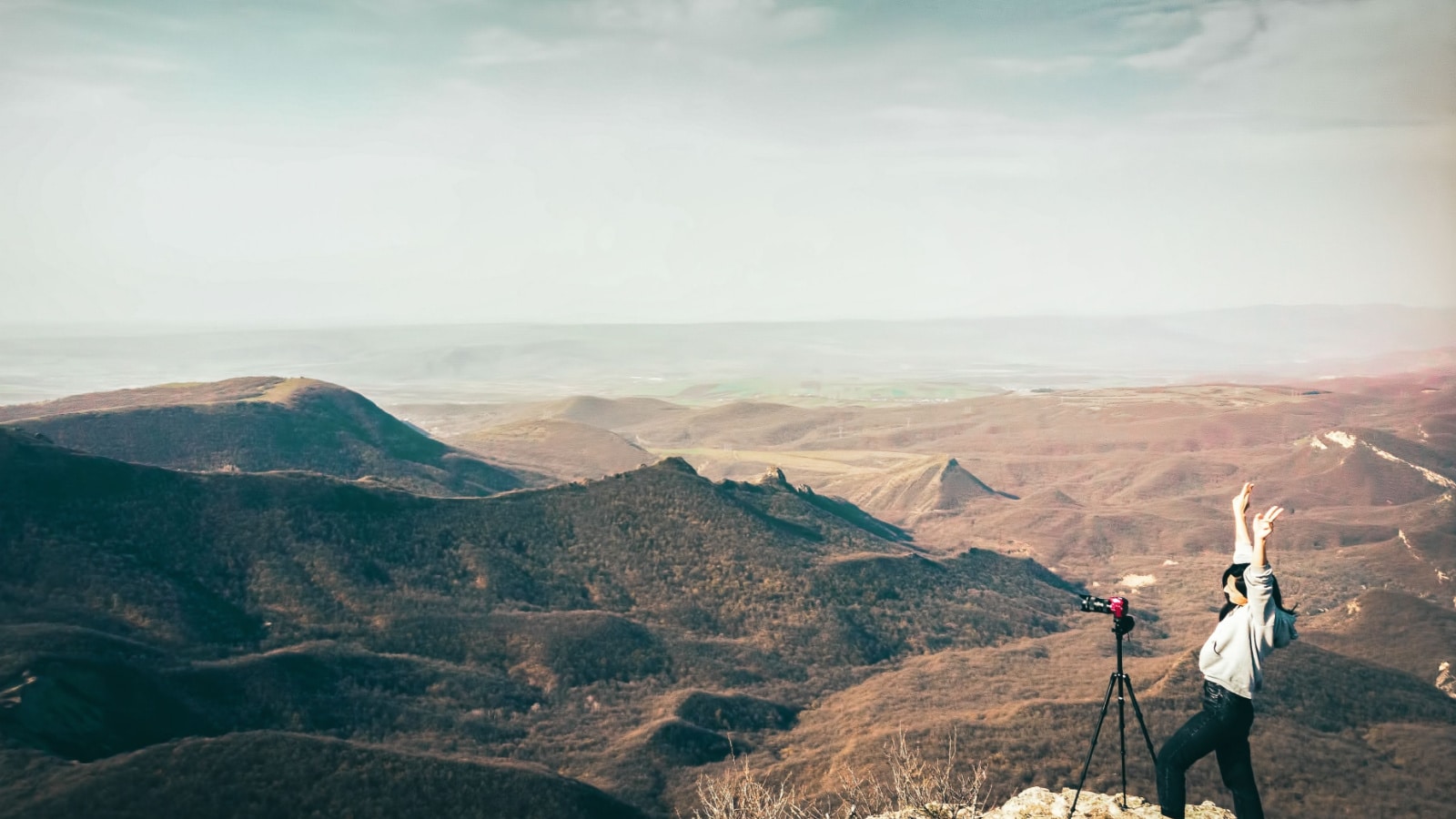 Young happy caucasian woman travel photographer excited shooting landscape outdoors