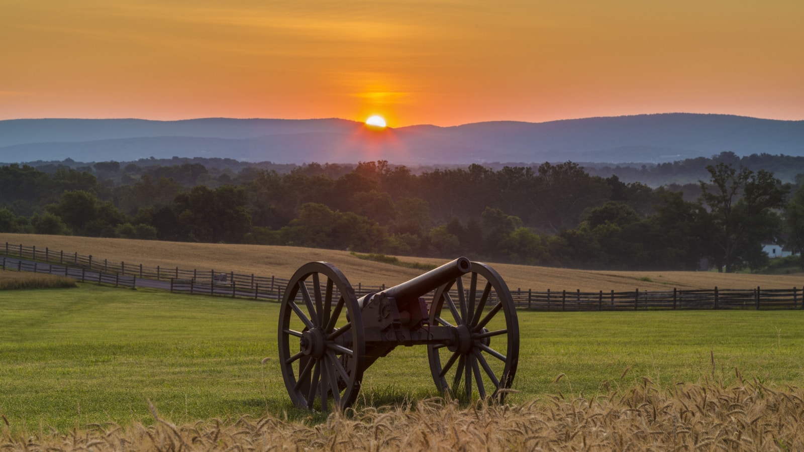 Sun rising behind artillery near a wheat field at Antietam National Battlefield in Sharpsburg, Maryland. The battle at Antietam was the bloodiest single-day battle in American history.