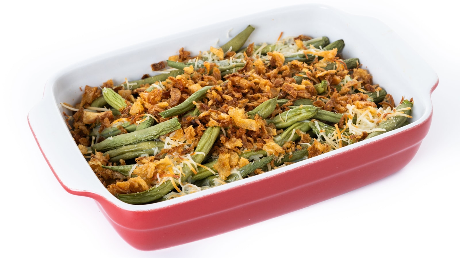 A traditional green bean casserole topped with French Fried Onions and cream of mushroom isolated on white background